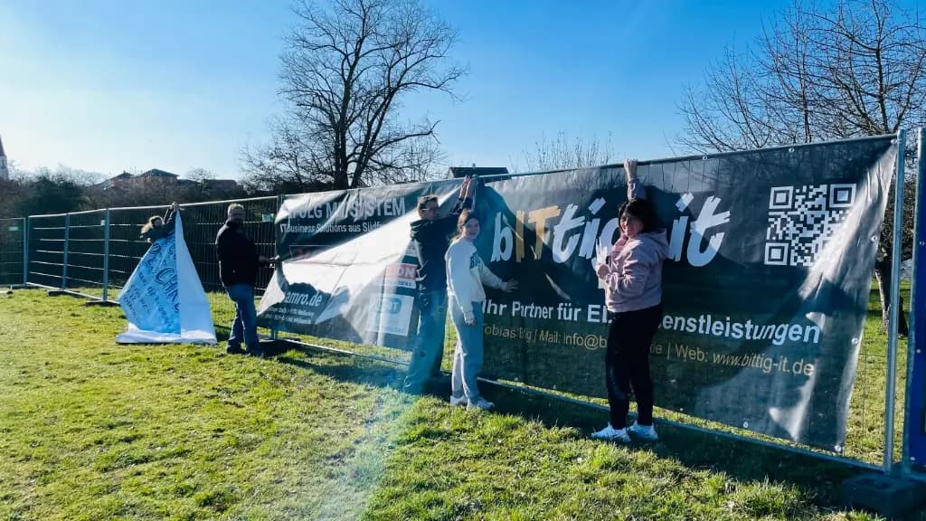 Helfer beim Aufbau der Banner am Sportgelände